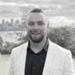 Toolbox Team: A black and white photo of Matthew soles with the Sydney harbour in the background